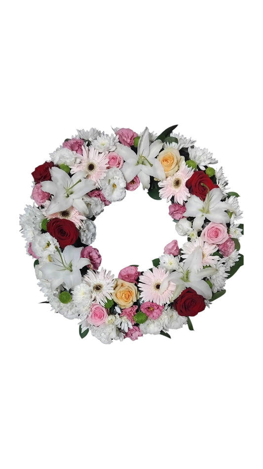 coroana funerara rotunda din rrandafiri roz ,rosii , crini albi mini gerbera roz si crizantema alba