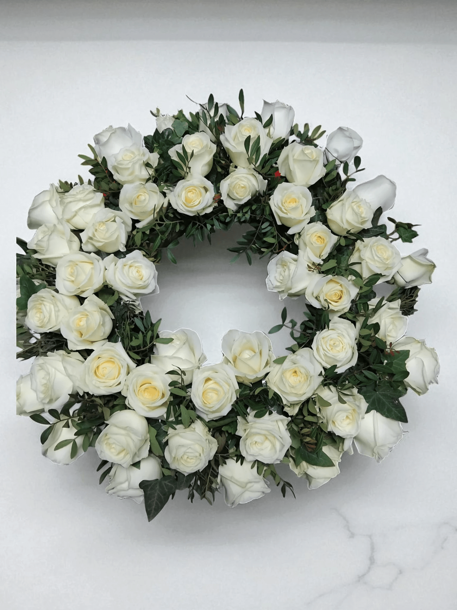 coroana funerara rotunda din trandafiri albi si frunze 