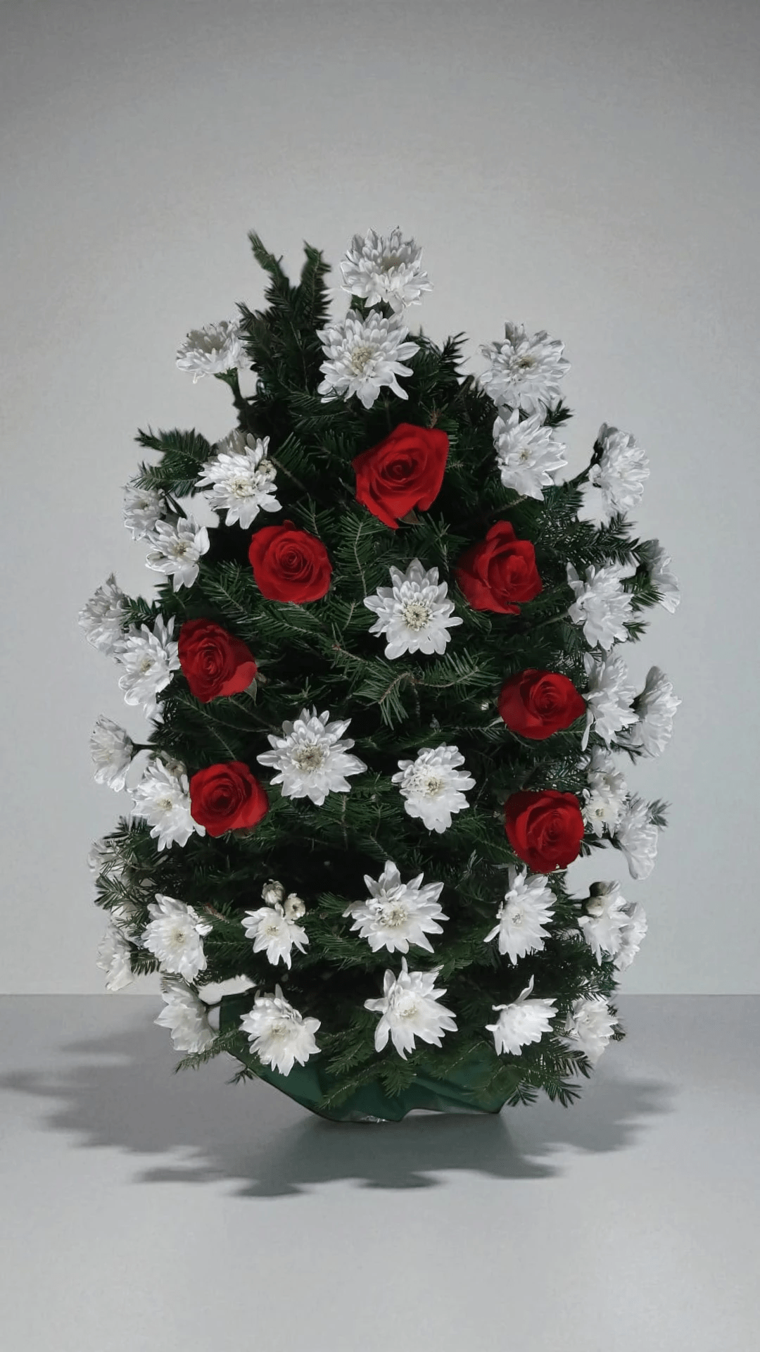 Jerba funerara din crizanteme albe si garoafe rosii pe mijloc
